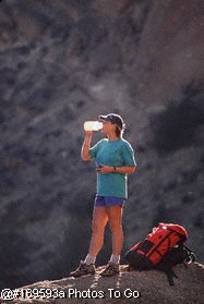 Woman drinking during mountain climb